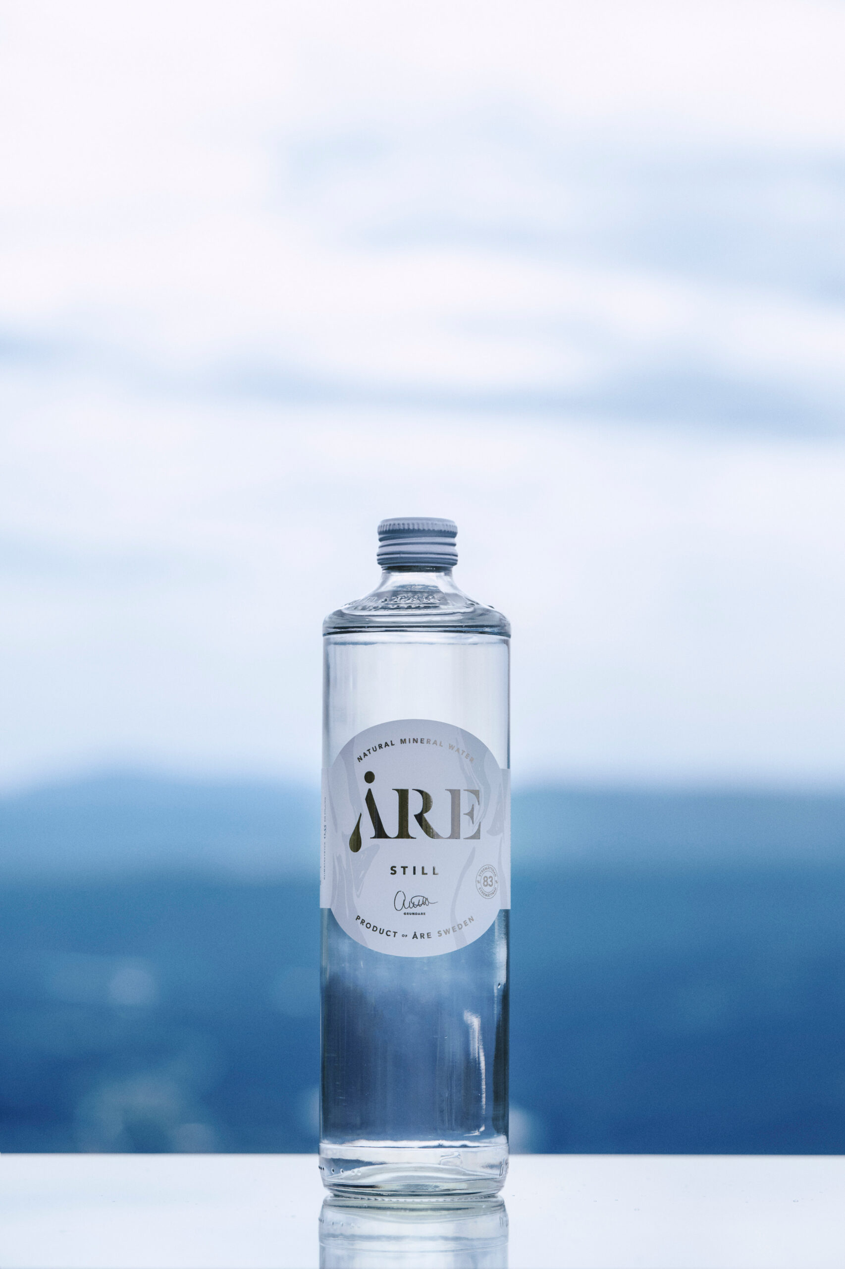 A glass bottle container filled with natural mineral water.