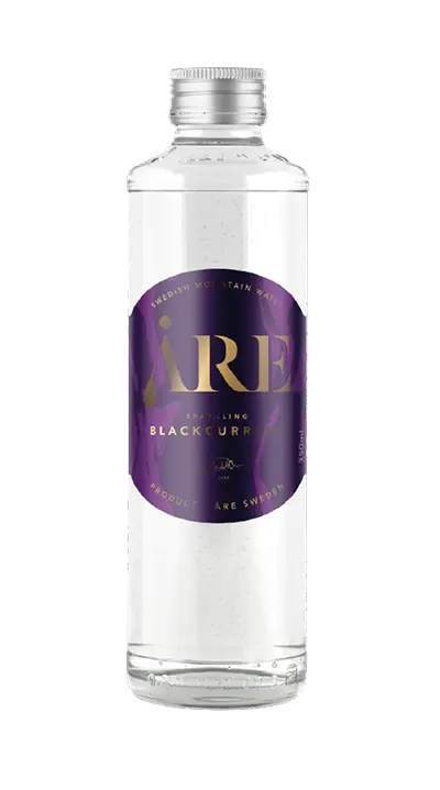 Glass bottle container filled with carbonated mineral water with blackcurrent flavor.